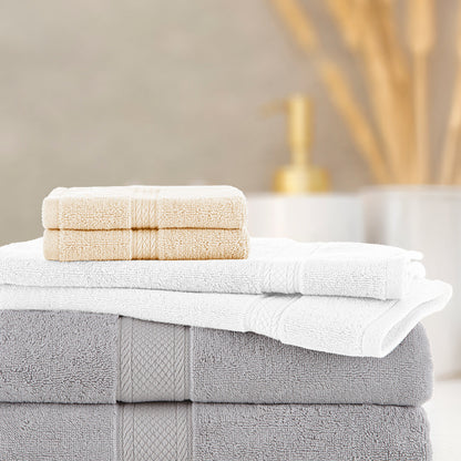 Stack of folded towels with a bar of soap on a neutral background