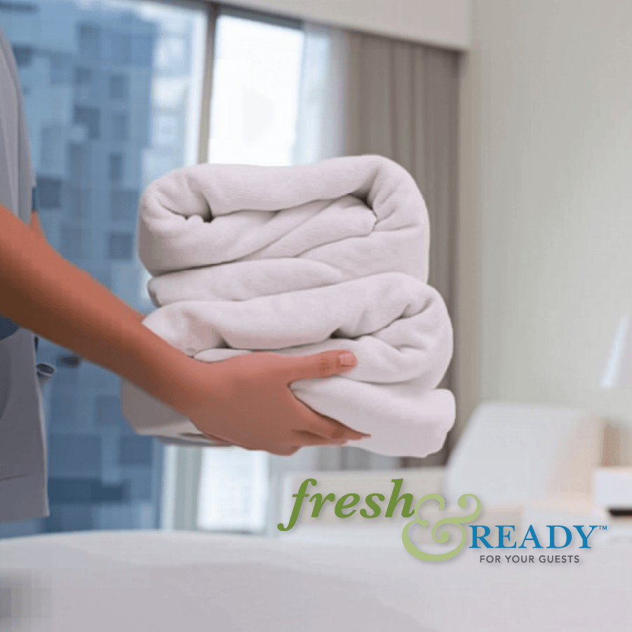 Person holding folded towels with 'fresh & ready' logo in the background