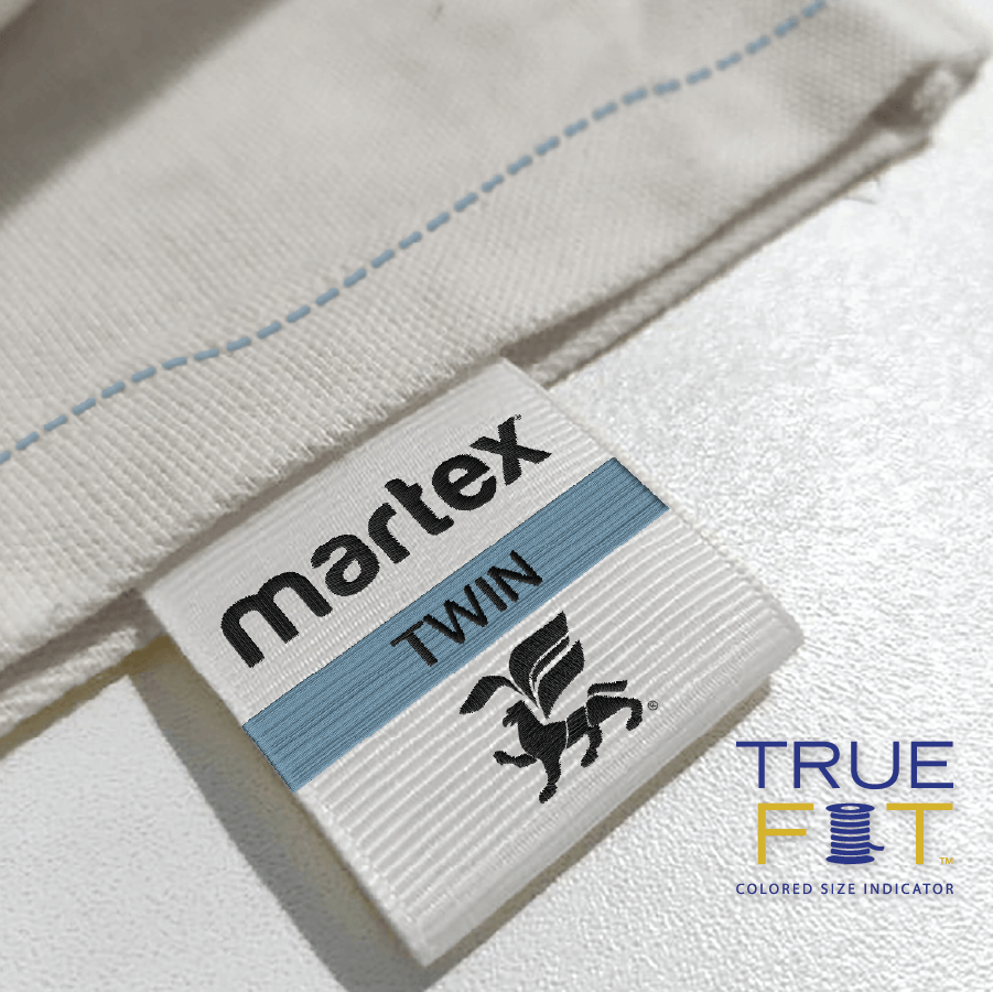 Close-up of a Martex Twin True Fit label on a white fabric background